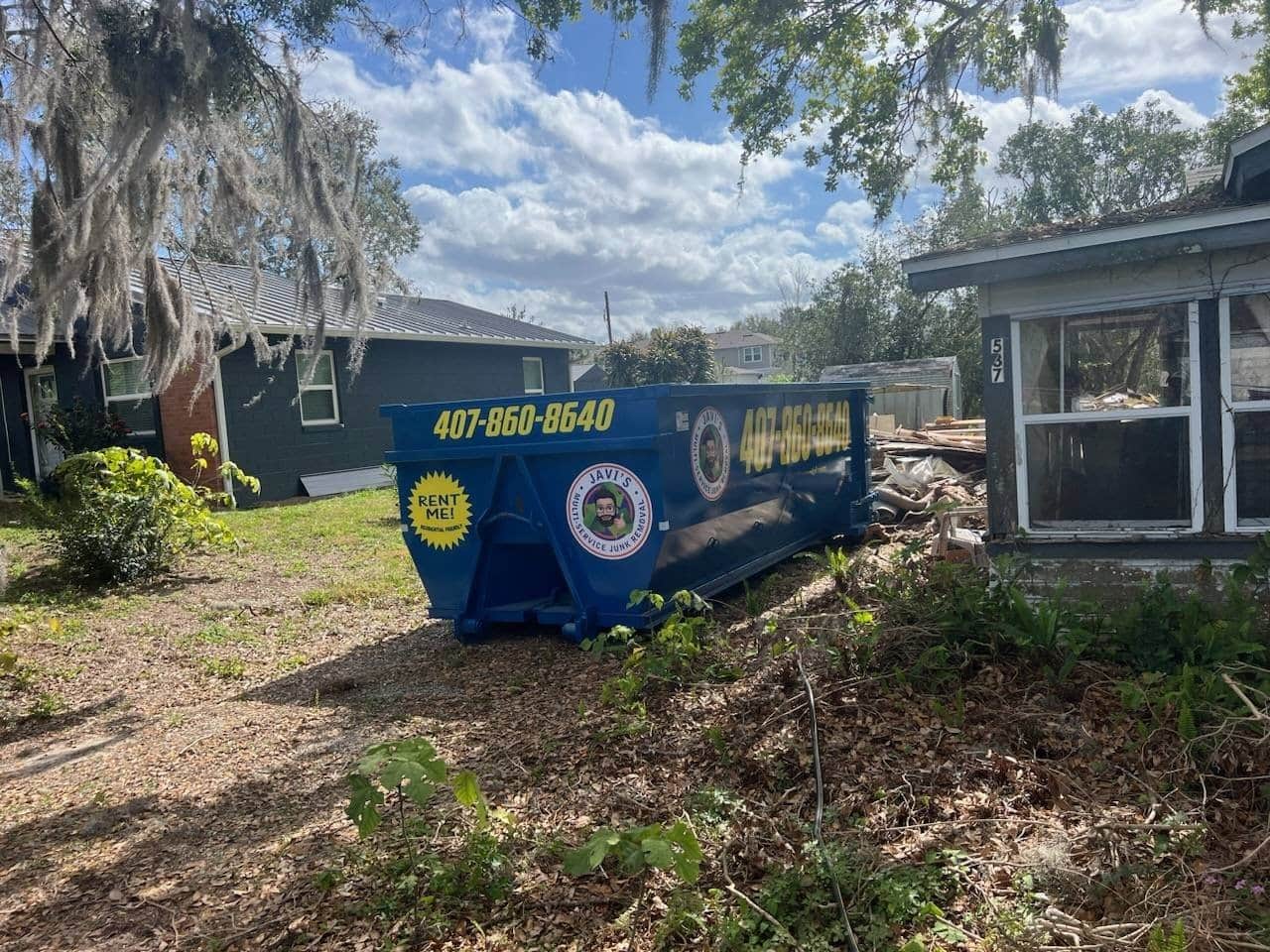 Contenedor roll-off colocado junto a una casa en renovación